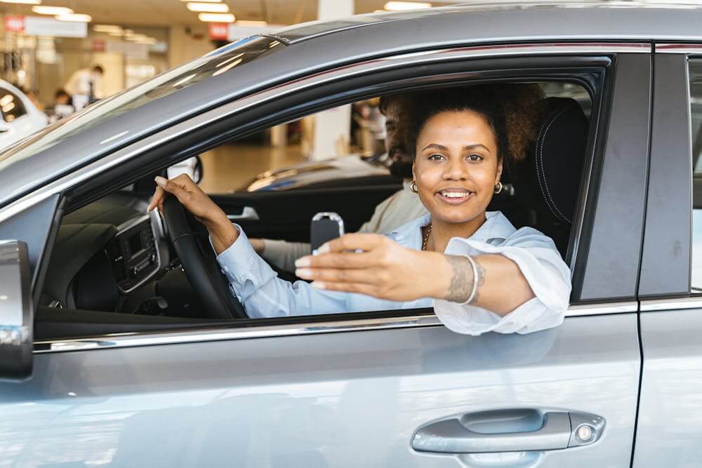 mulher dentro do carro alugado com chave na mão