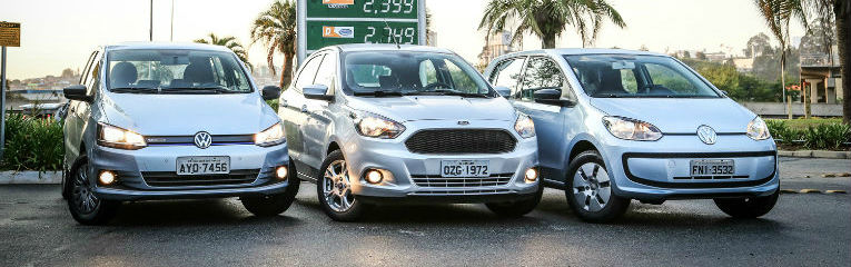 Visão frontal de três carros cinza estacionados.