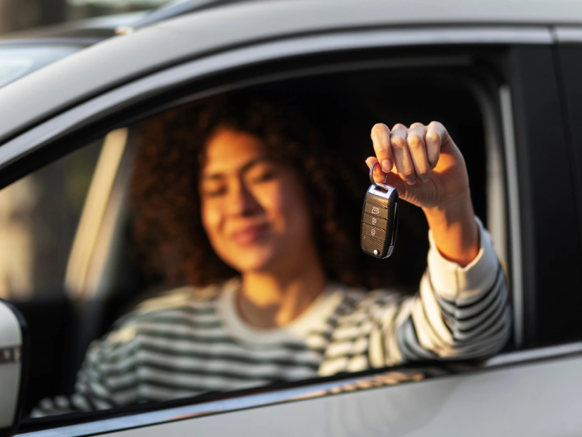 jovem segurando a chave de carro alugado