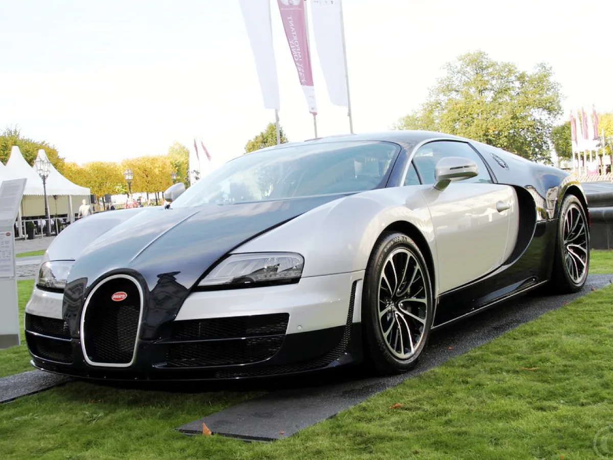 Bugatti Veyron (2005) na cor bege com amplo detalhe em preto no capô dianteiro, laterais e parte traseira, estacionado num pátio externo.