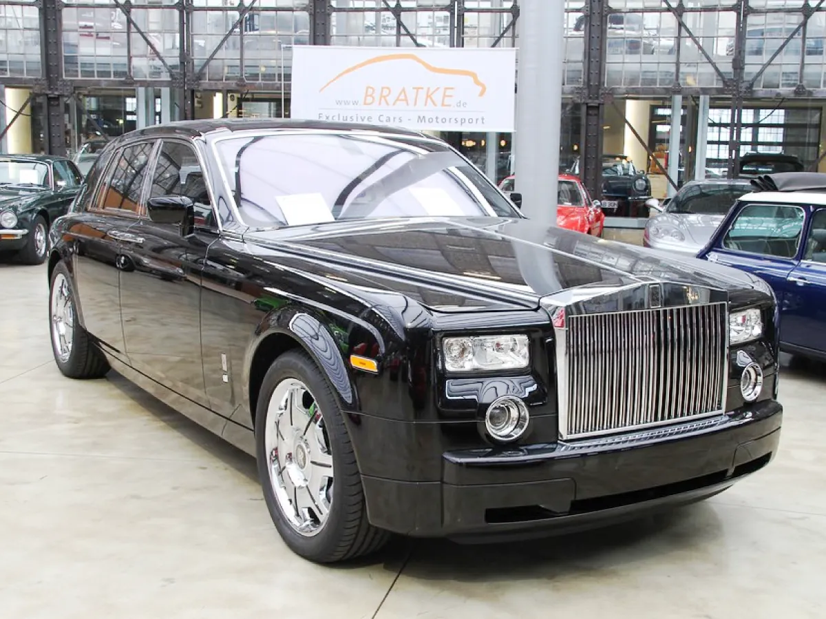 Rolls-Royce Phantom (2003) na cor preta estacionado em pátio de exposição ao lado de outros carros.