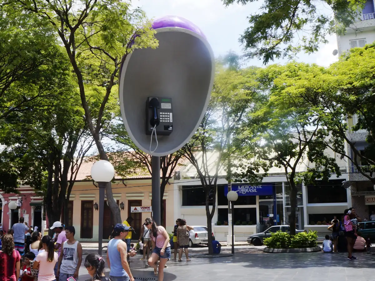 Orelhão gigante, turistas e moradores em praça de Itú