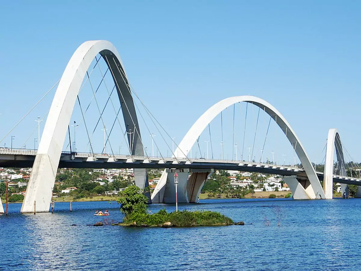 Ponte JK (Juscelino Kubitscheck) com seus três arcos assimétricos sobre o Lago Paranoá, num dia ensolarado e céu limpo.