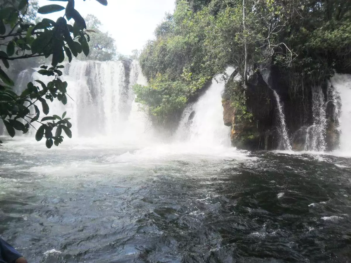 Queda d'água da cachoeira do Redondo, em Barreiras. Paisagem repleta de vegetação e um céu praticamente nublado.