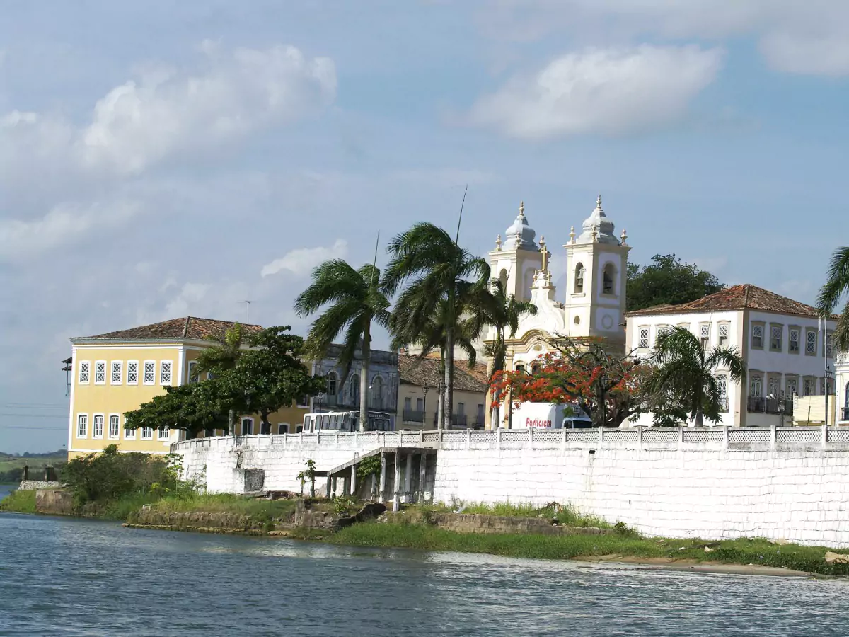 Um muro separa o Rio São Francisco do centro histórico de Penedo, em Alagoas. Ao fundo, podemos vislumbrar casarões coloniais de dois andares, além da igreja Nossa Senhora da Corrente.