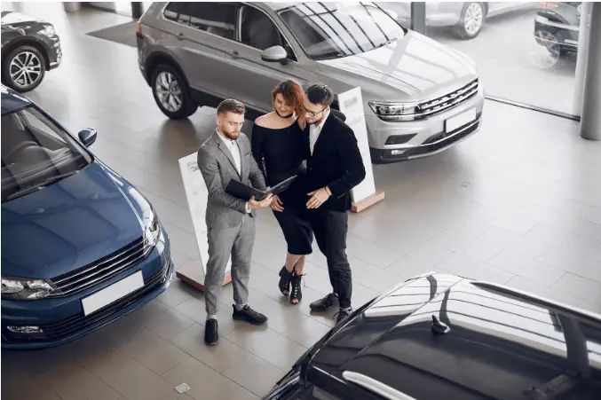 casal conversando com vendedor de carro